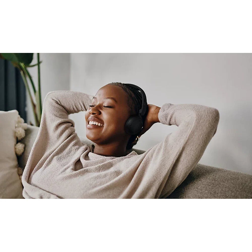 سماعات Philips TAH2209 Black – سماعات على الأذن خفيفة بوزن 141 غراماً، حتى 25 ساعة، جهير Dynamic Bass، بلوتوث 5.4 متعدد الأجهزة، وضع تأخير منخفض للفيديو 8 شخص يرتدي سماعات Philips TAH2209 Black